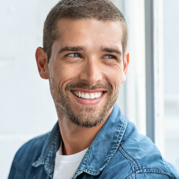 man in jean jacket smiling