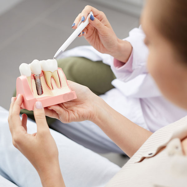 patient looking at model of dental implant