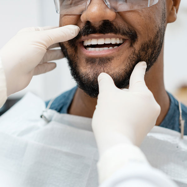 doctor examining mans mouth