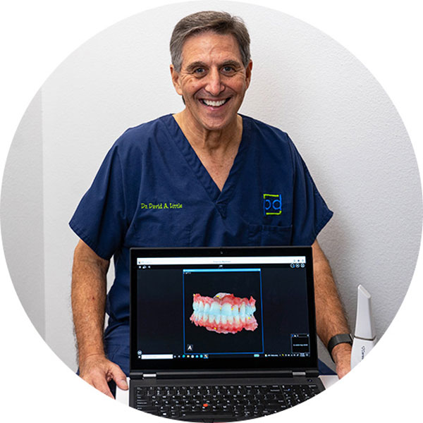 Dr. Little standing by laptop of dental imaging
